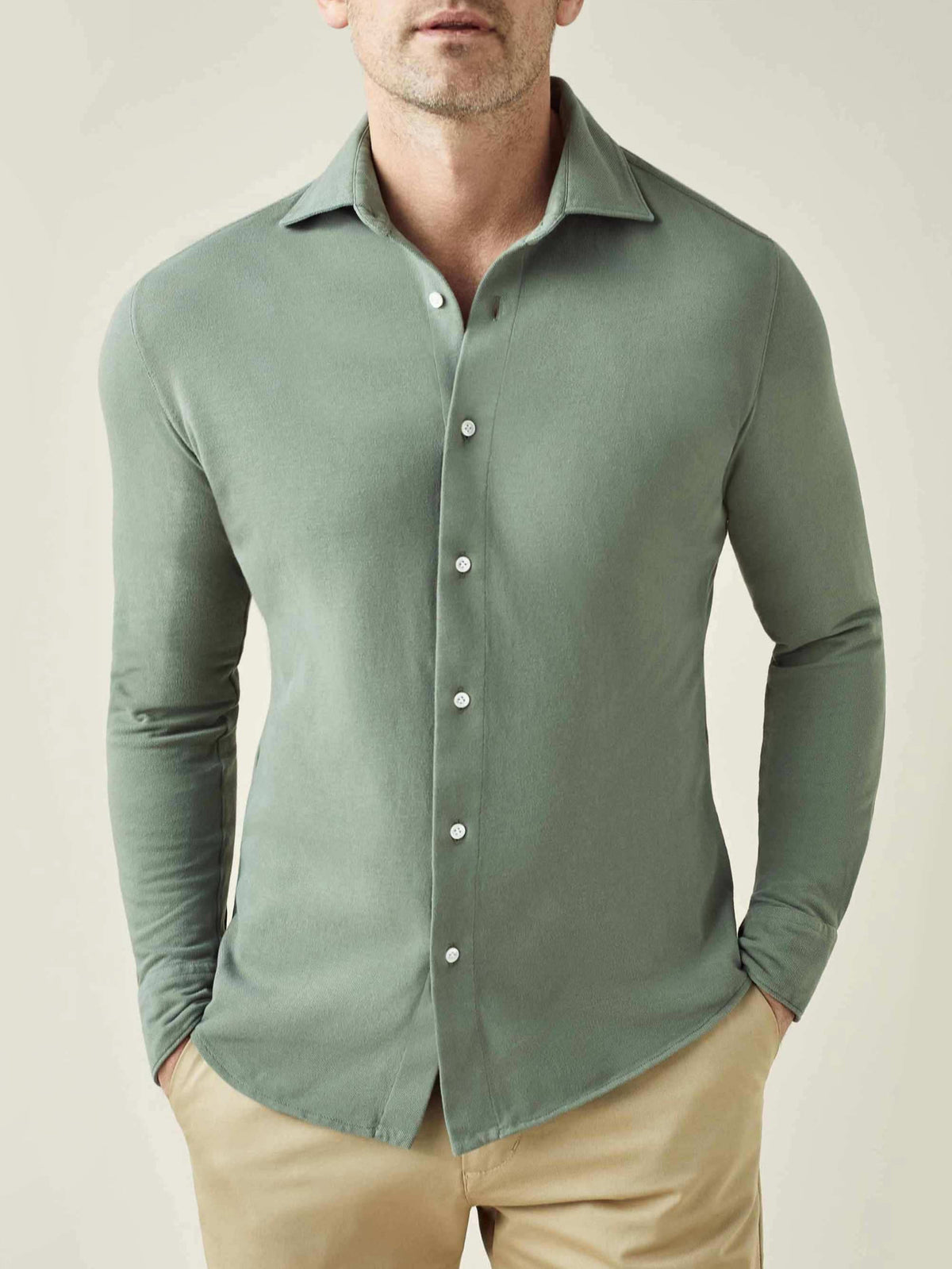 Front view of a model wearing the Luca Faloni Siena Piqué Shirt in Sage Green, styled with light-coloured chinos.