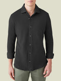 Front view of a model wearing the Siena Piqué Shirt in charcoal grey with the sleeves rolled up.