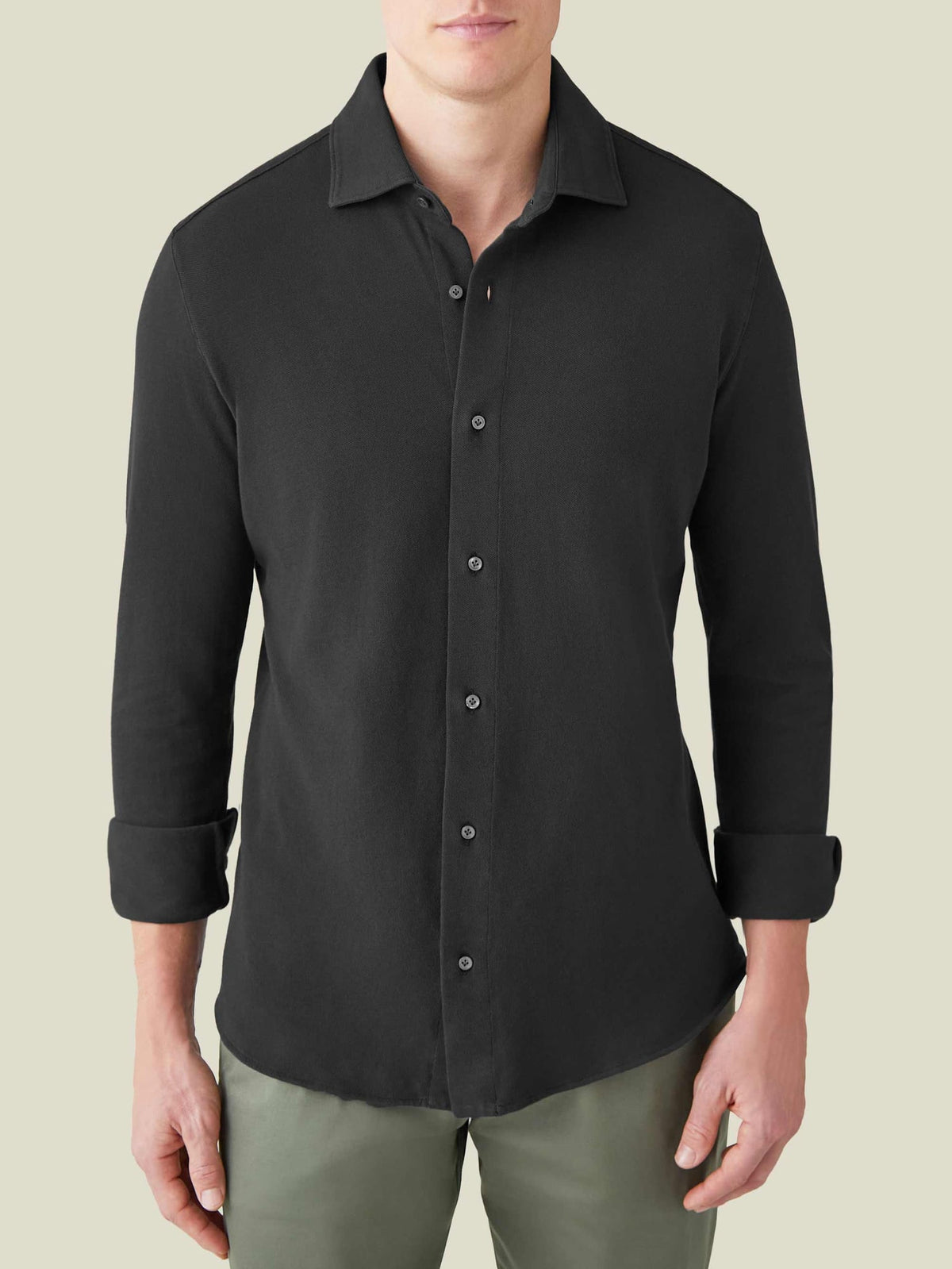 Front view of a model wearing the Siena Piqué Shirt in charcoal grey with the sleeves rolled up.