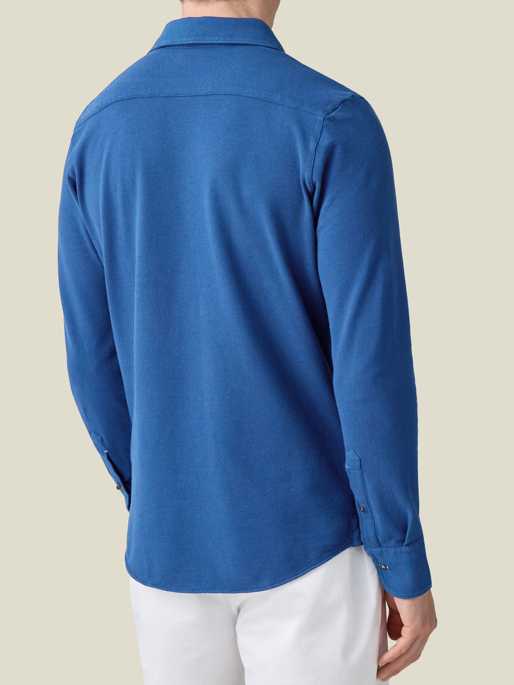 Back view of a model wearing the Siena Piqué Shirt in royal blue.