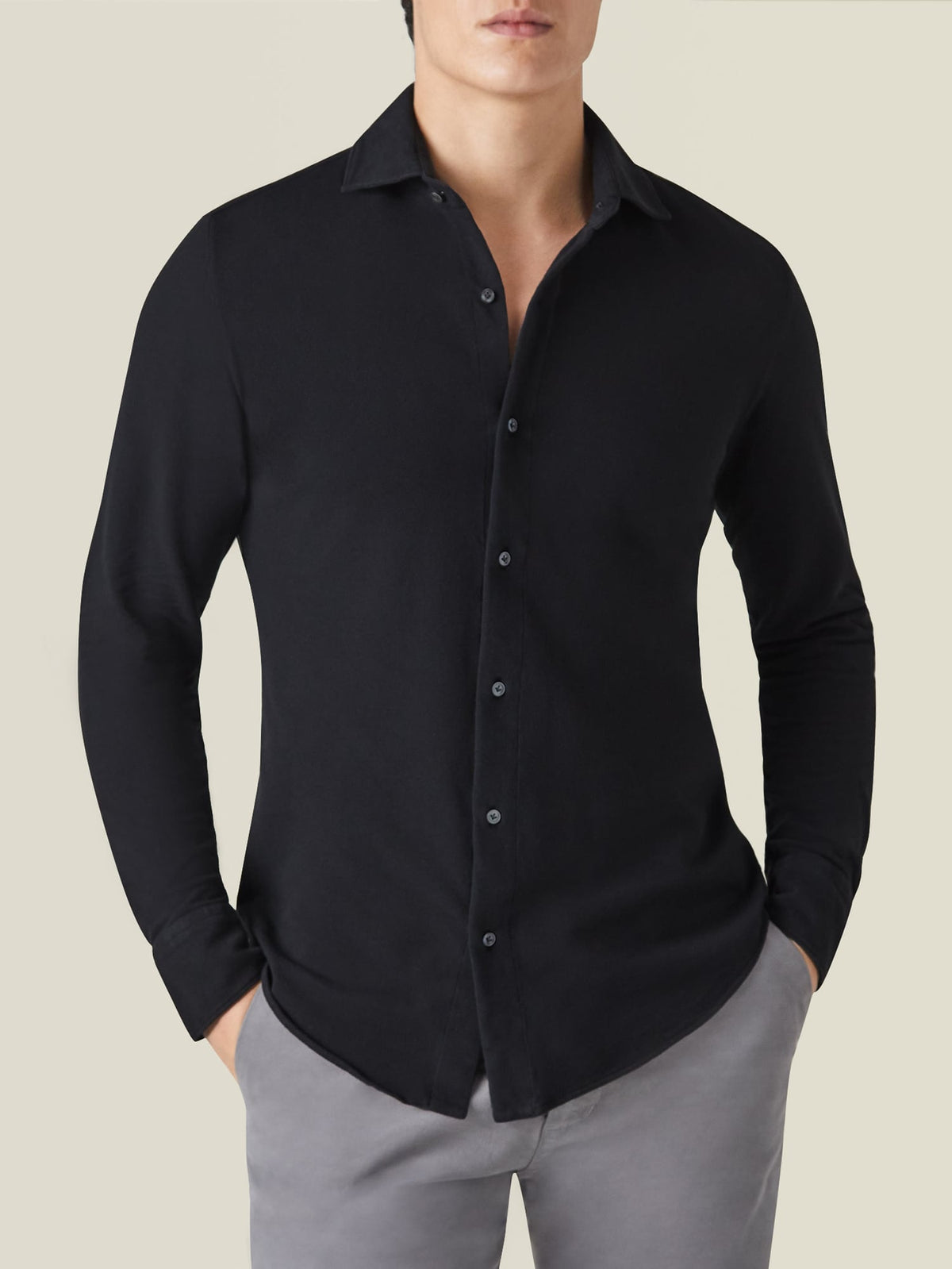 Front view of a model wearing the Luca Faloni Black Siena Piqué Shirt with grey trousers.
