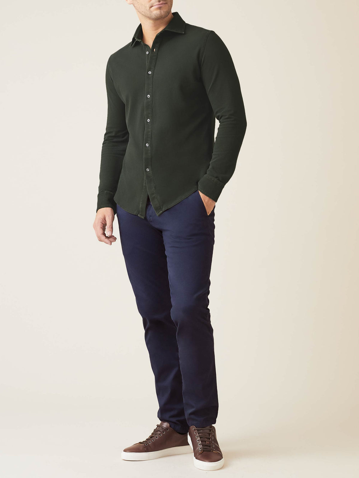 A model wears the Luca Faloni Forest Green Siena Piqué Shirt, styled with dark blue trousers and brown leather sneakers.