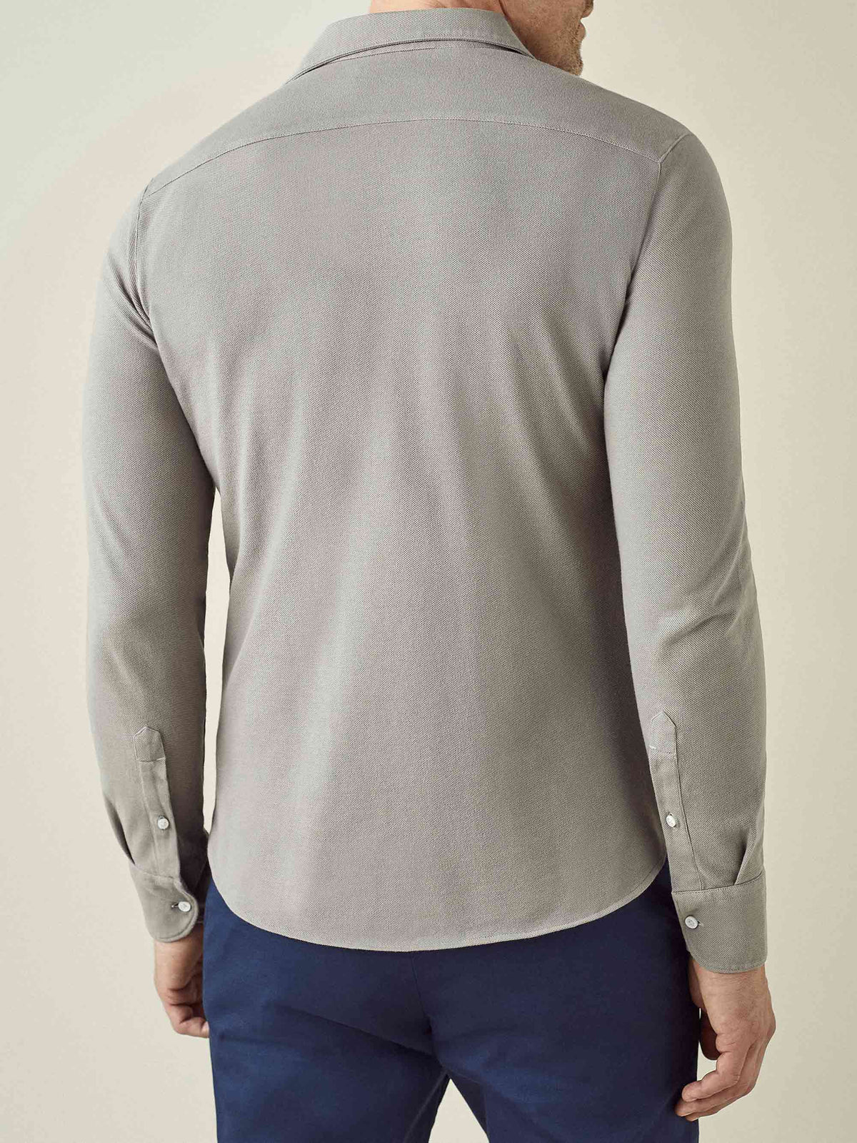 Back view of a model wearing the Siena Piqué Shirt in Dove Grey.