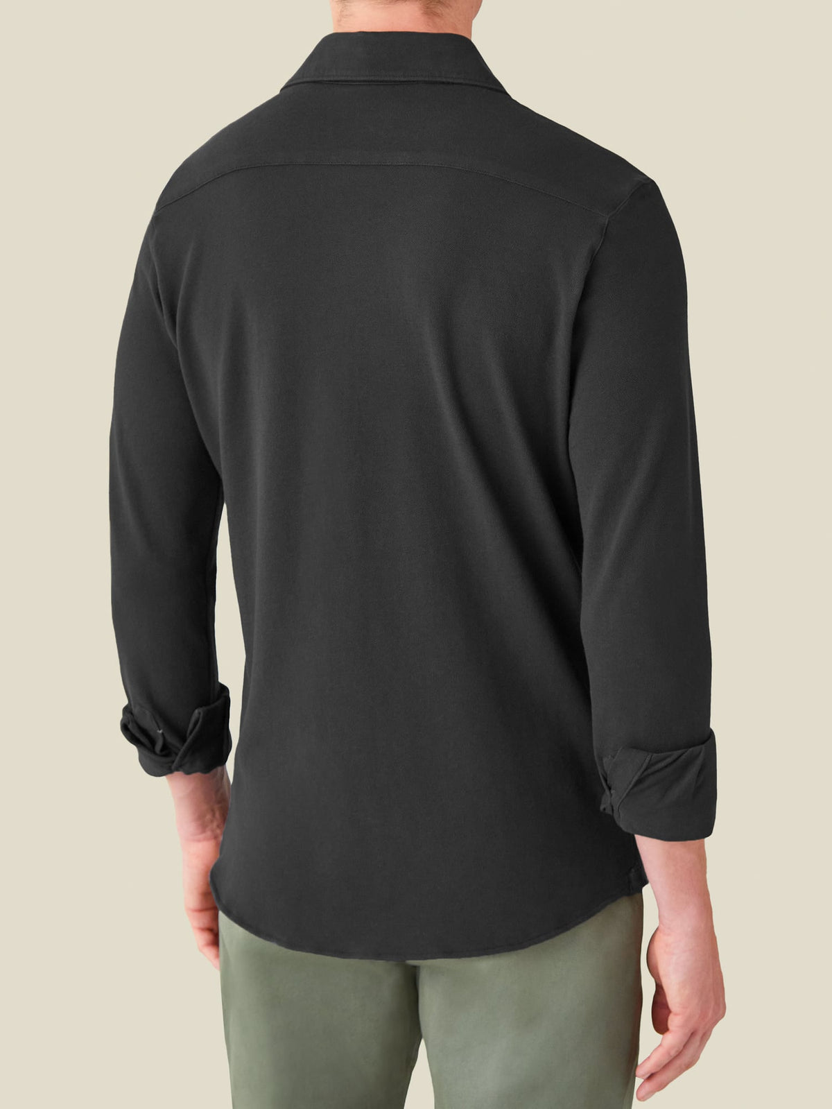 Back view of a model wearing the long-sleeve Siena Piqué Shirt in charcoal grey.