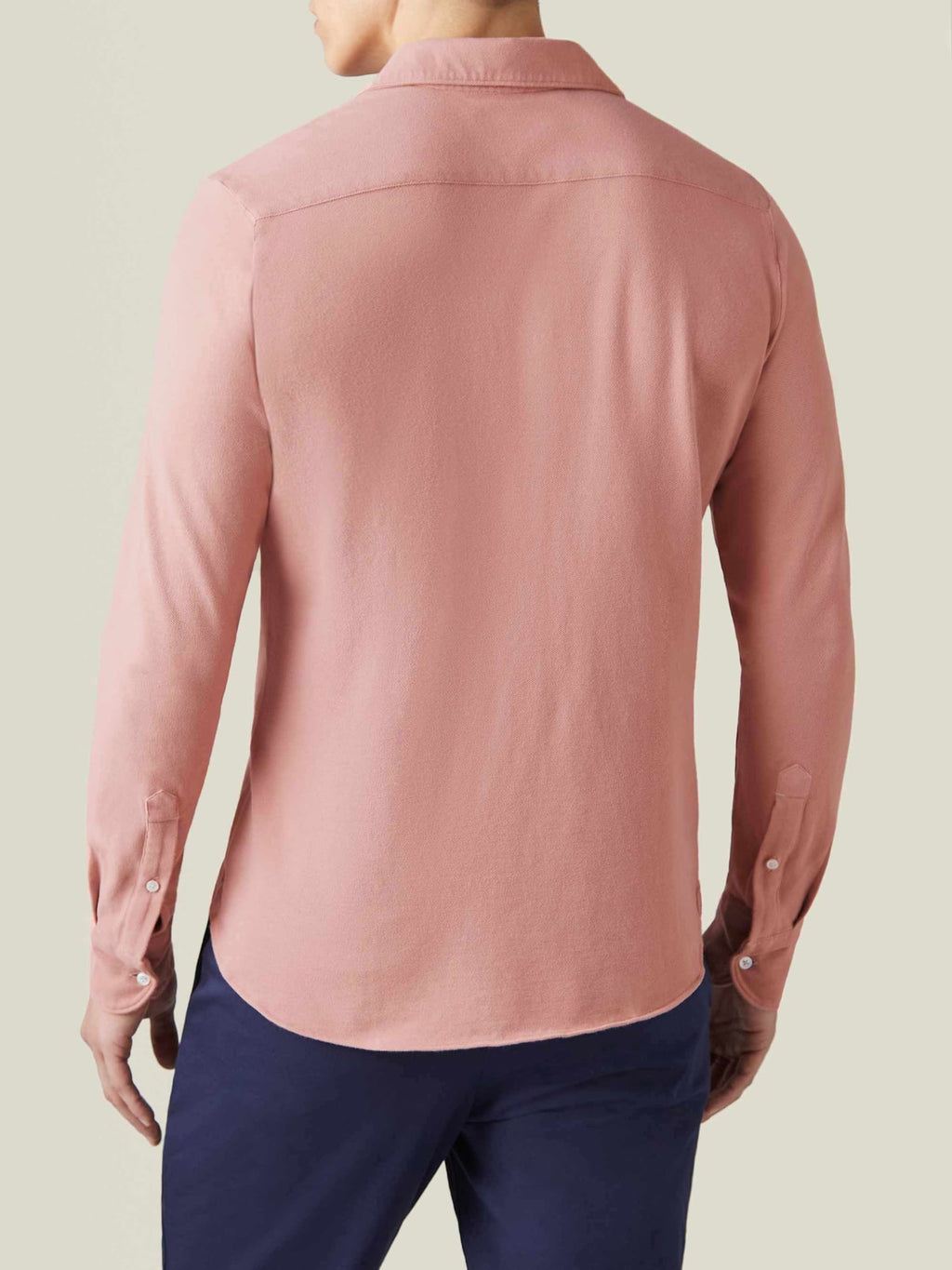Siena Piqué Shirt in peach worn by a model, shown from the back to highlight the fit and rounded hemline.
