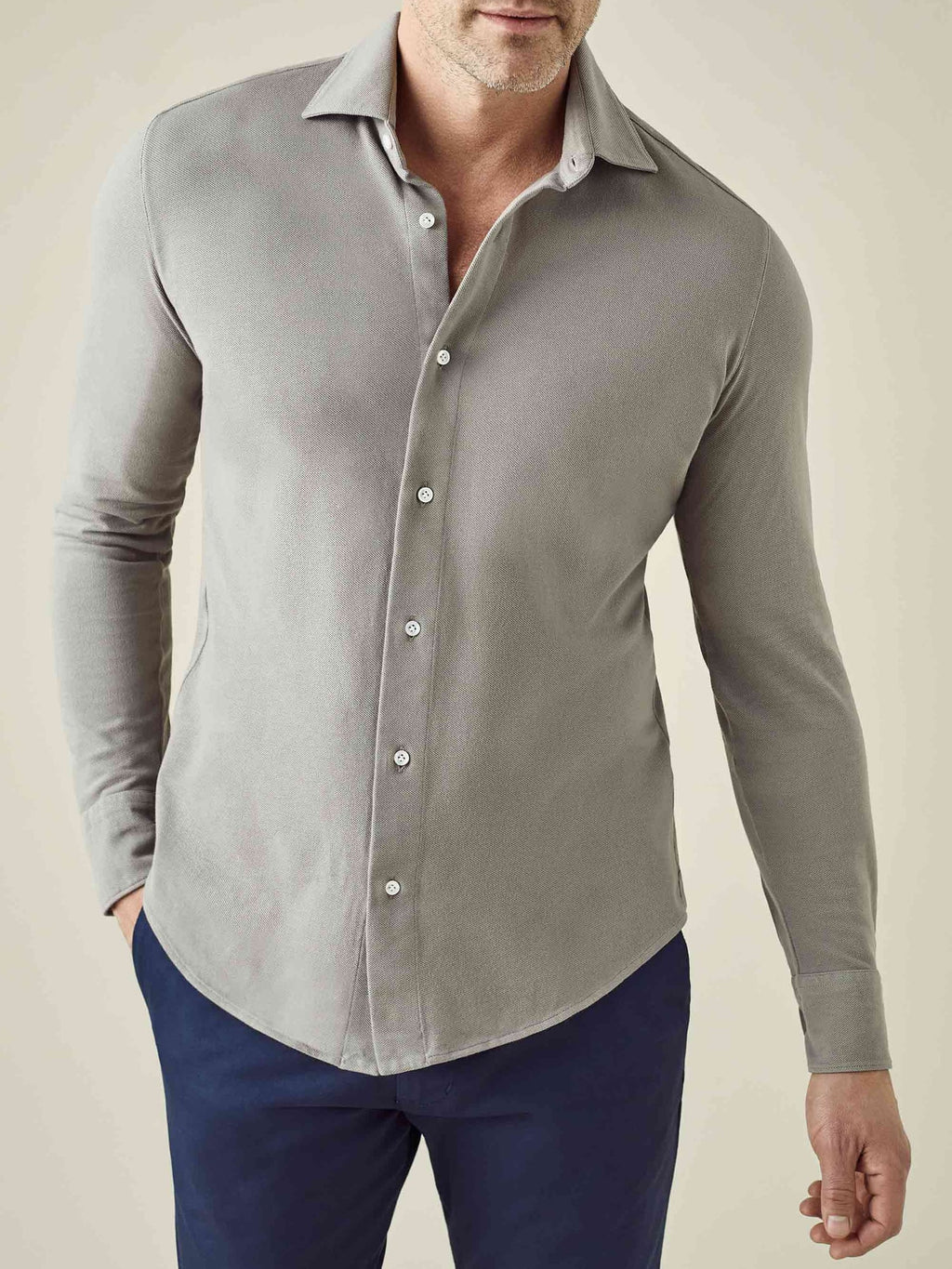 A model wears the Siena Piqué Shirt in Dove Grey, showing the relaxed fit and cotton texture, paired with navy trousers.