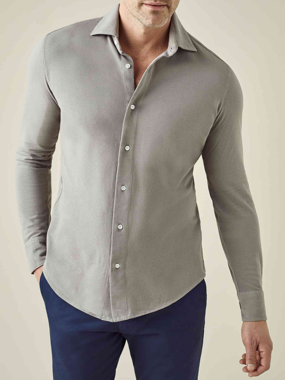 A model wears the Siena Piqué Shirt in Dove Grey, showing the relaxed fit and cotton texture, paired with navy trousers.