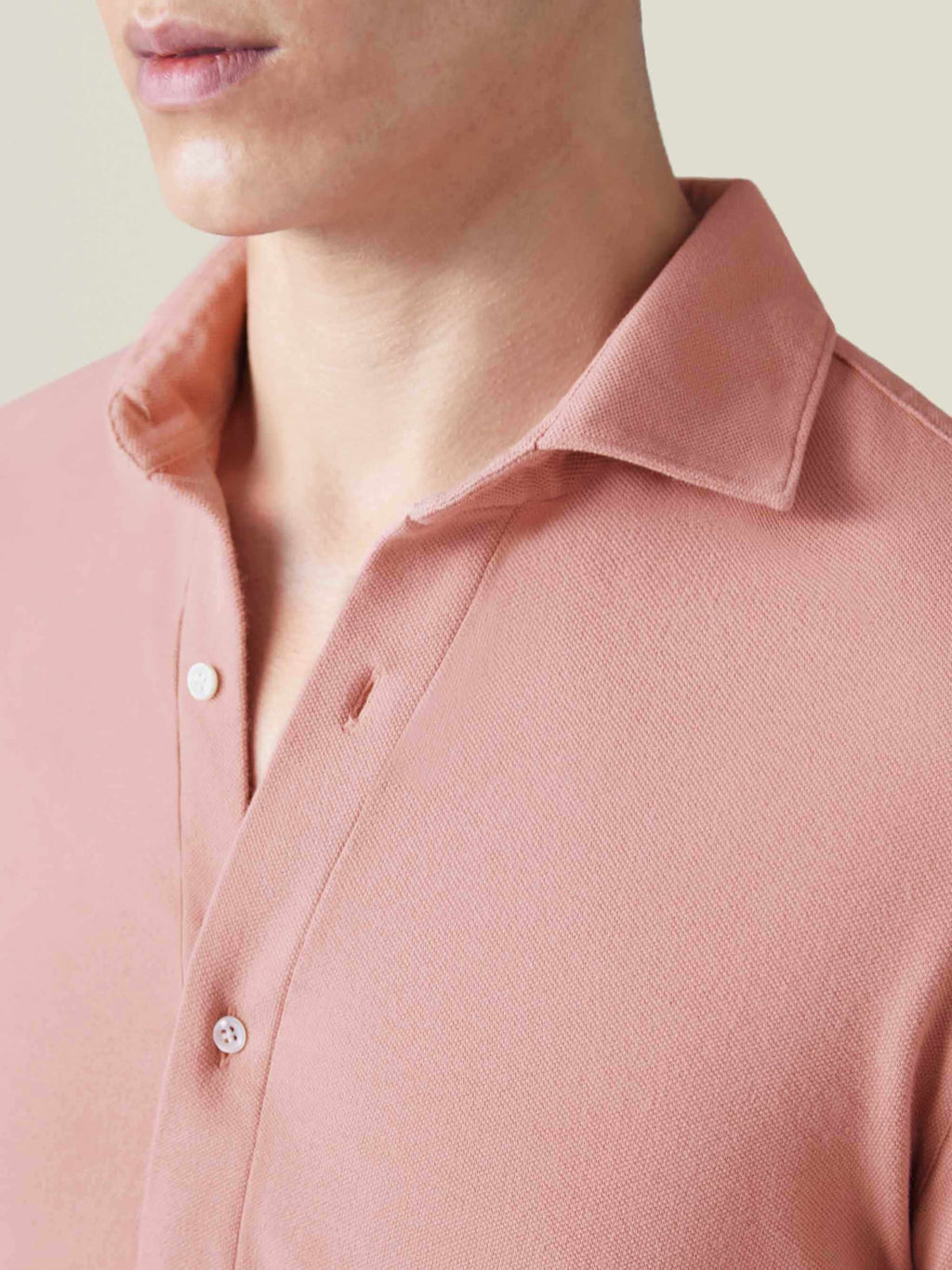 Close-up of the Siena Piqué Shirt in peach, showing the textured cotton piqué fabric and the cutaway collar.
