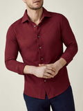 Model wears the long-sleeved Siena Piqué Shirt in burgundy. Front view showcasing the comfortable fit and textured fabric.