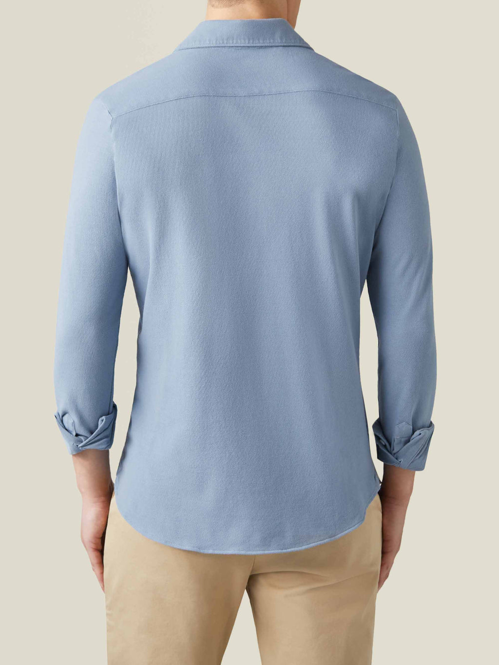 Back view of a model wearing the Siena Piqué Shirt in French Blue, showcasing the relaxed fit and rounded hem.