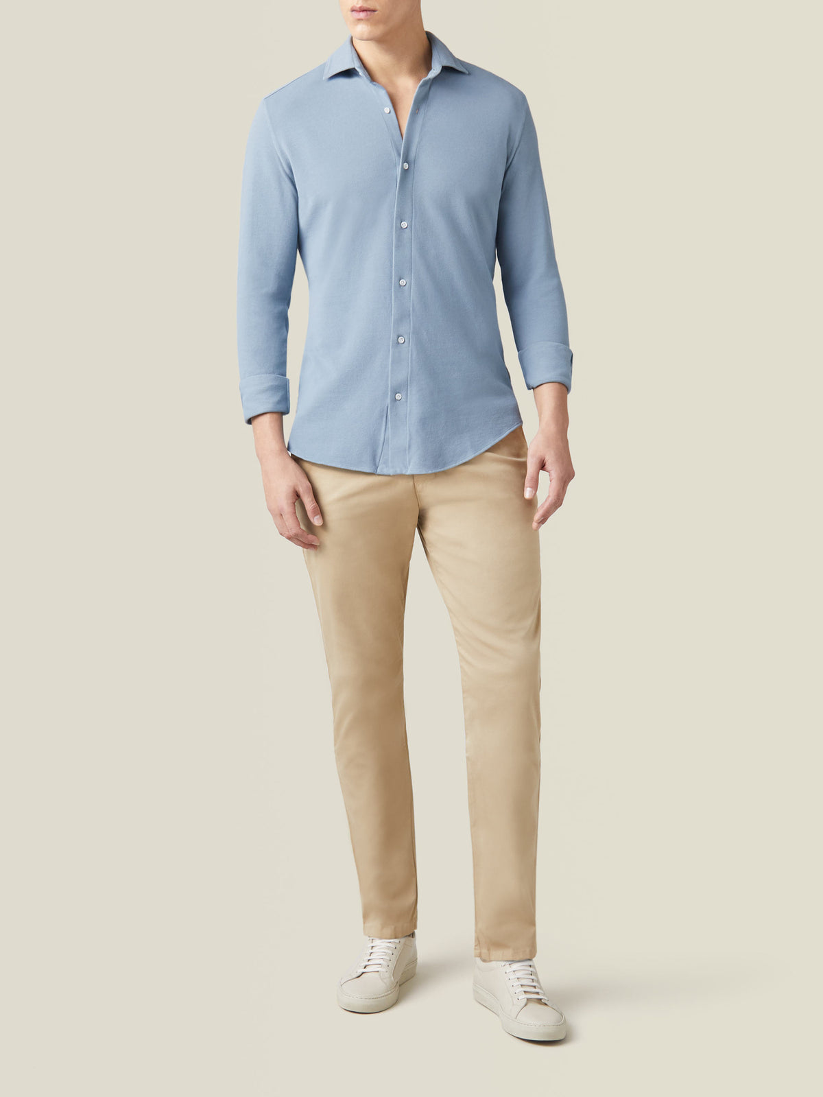 Front view of a model wearing the Siena Piqué Shirt in French Blue, styled with beige chinos and white sneakers.