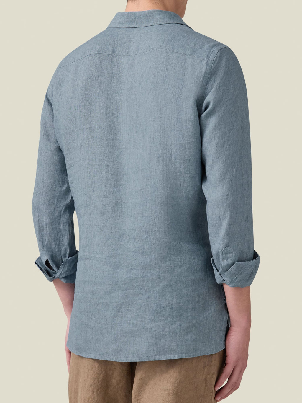 Rear view of a man wearing the French Blue Ravello Linen Shirt with sleeves rolled up to show the relaxed fit.