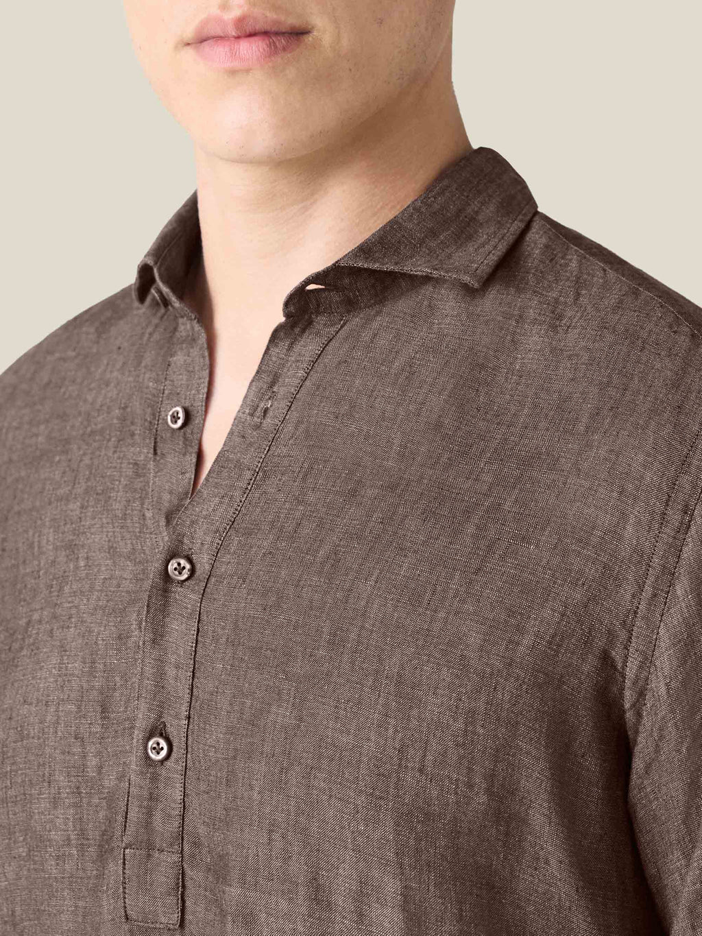 Detailed close-up on the cutaway collar and popover placket of the Chocolate Brown Ravello Linen Shirt, worn by a model.
