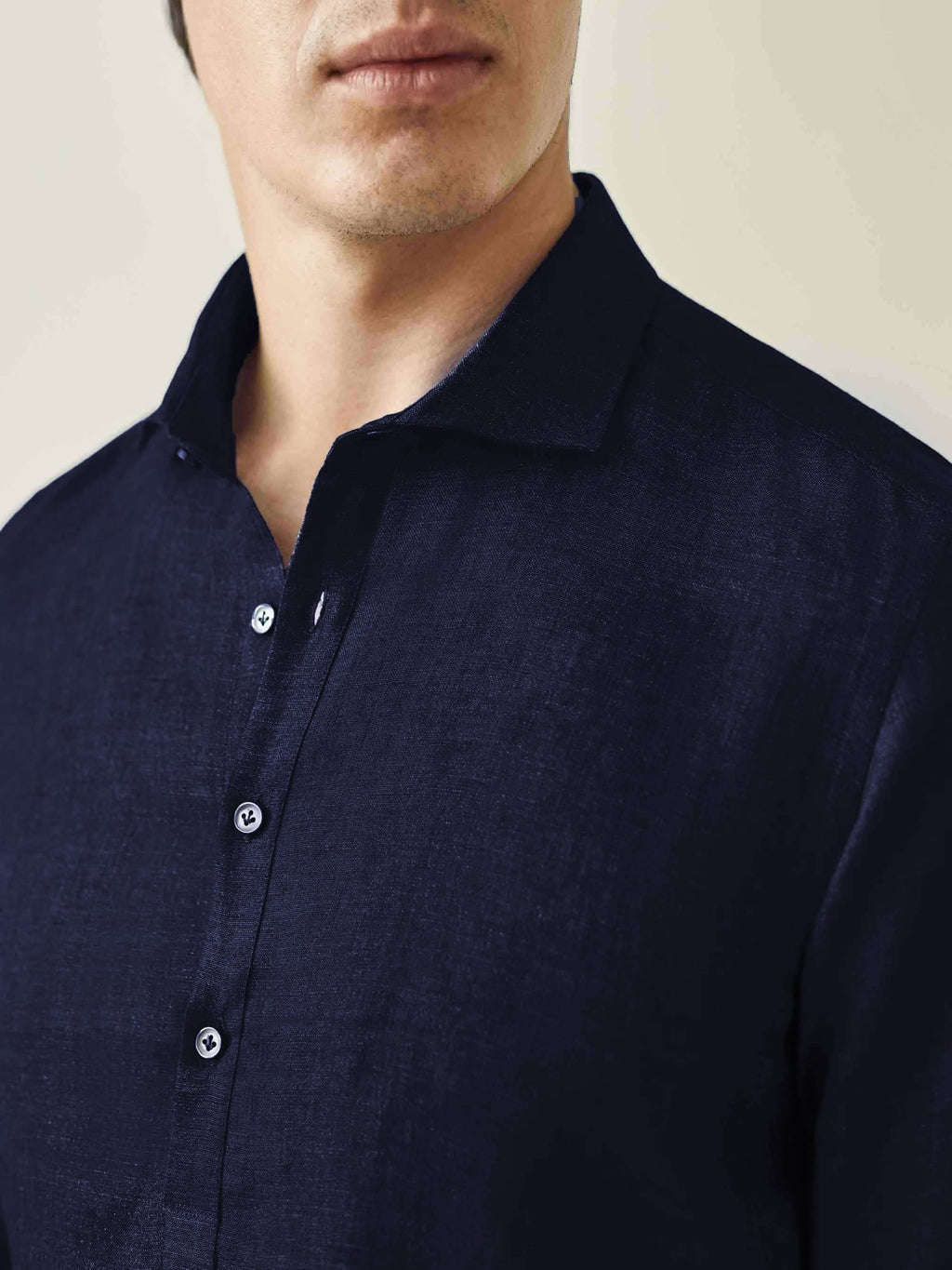 Close-up of the Ravello Linen Shirt in midnight blue, showing the detail of the cutaway collar and mother of pearl buttons.