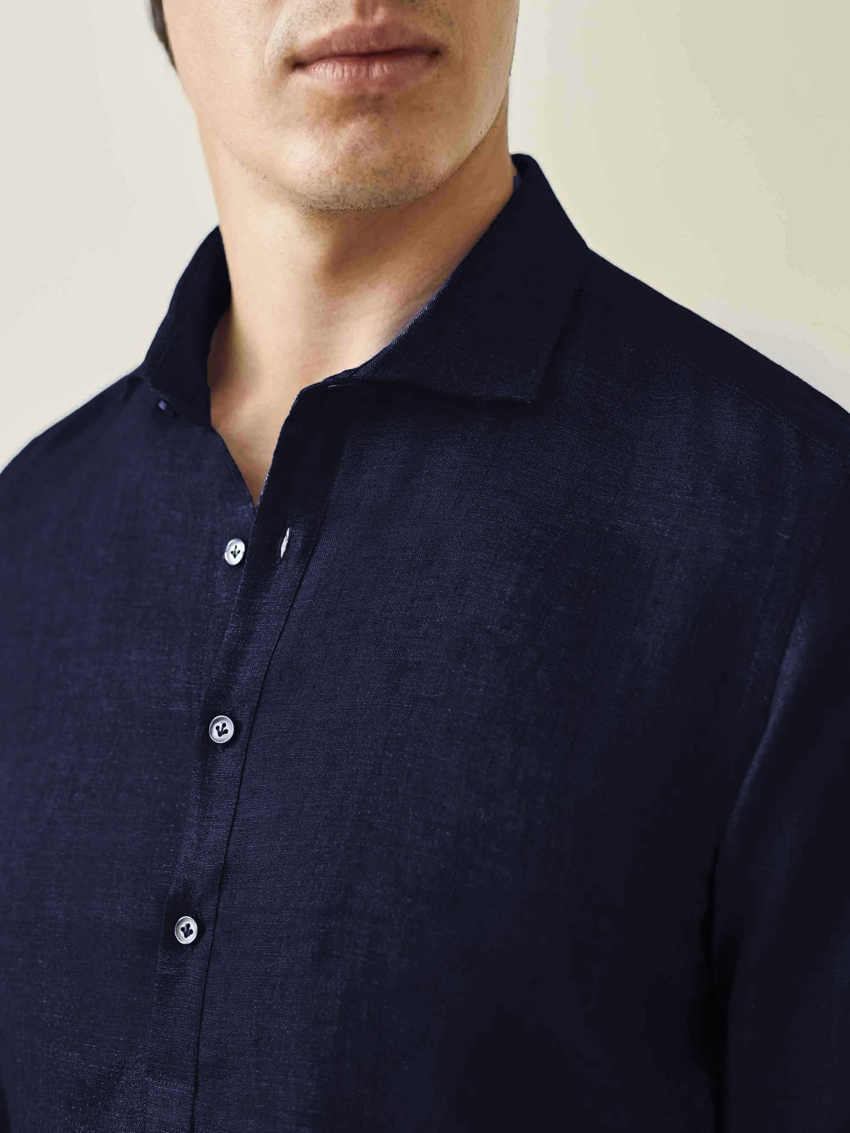 Close-up of the Ravello Linen Shirt in midnight blue, showing the detail of the cutaway collar and mother of pearl buttons.