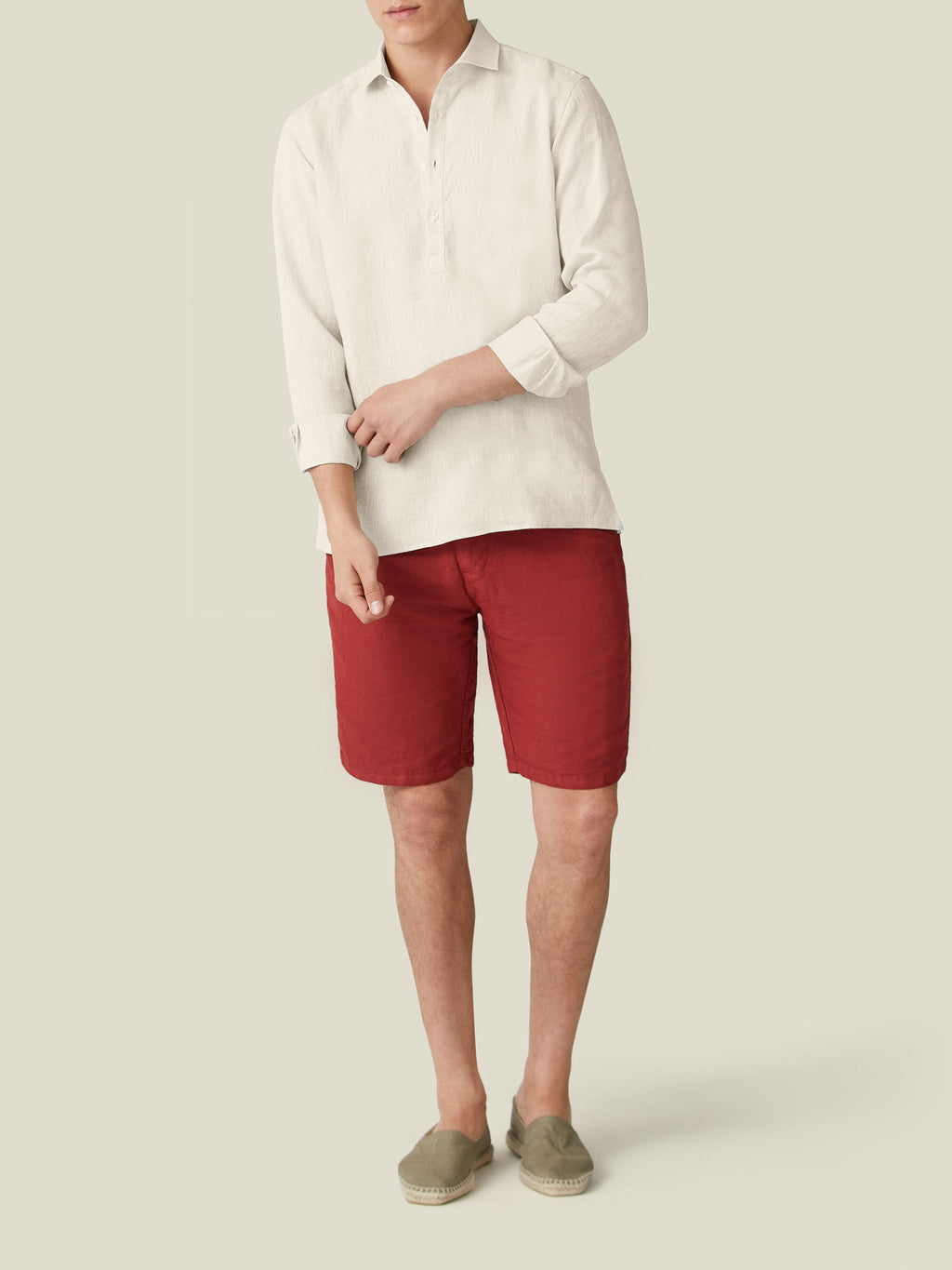 Full-length view of a model wearing the Luca Faloni sand Ravello Linen Shirt, styled with red shorts and sand espadrilles.