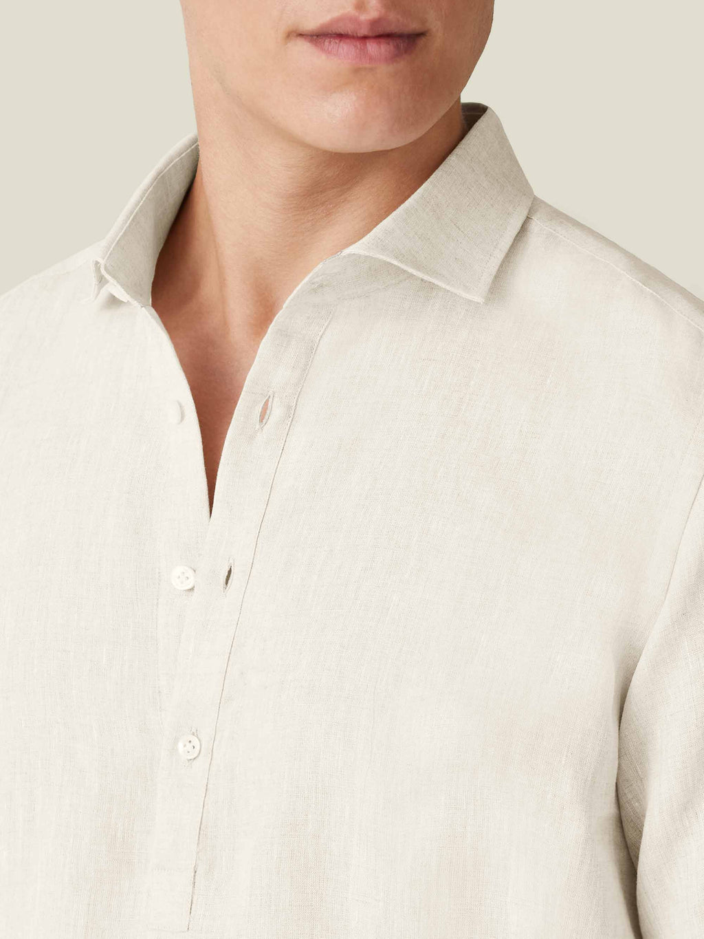 Close-up detail of the Ravello Linen Shirt in sand, showcasing the cutaway collar and fine Italian linen fabric.