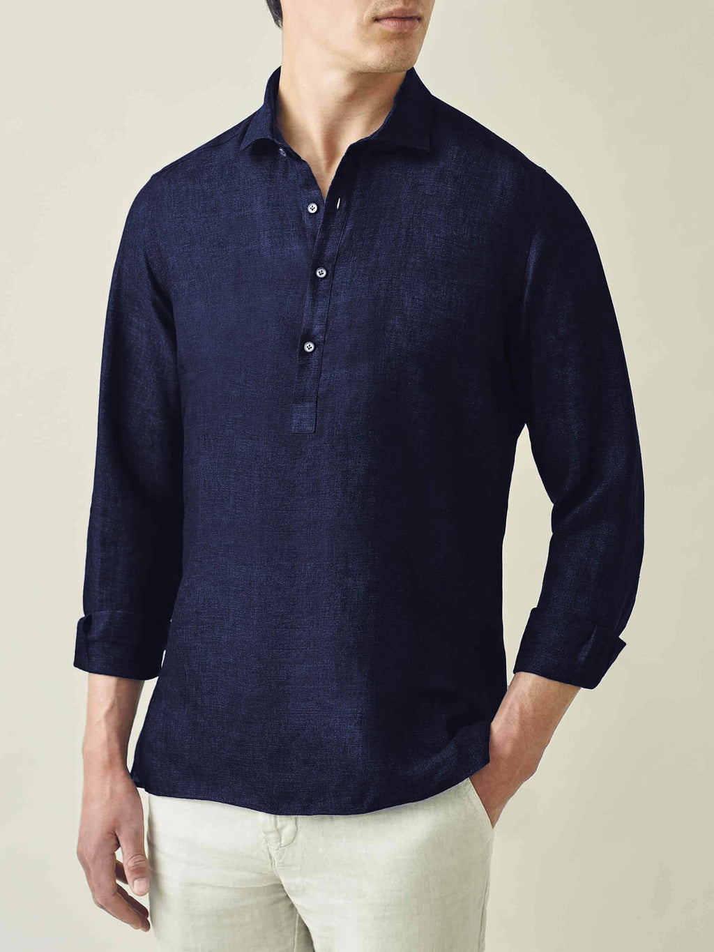 A model wears the Ravello Linen Shirt in Midnight Blue, styled with light-coloured trousers.