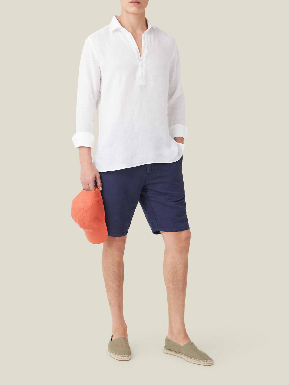 Full-length view of a model wearing the Ravello Linen Shirt in white, styled with navy shorts and beige espadrilles.