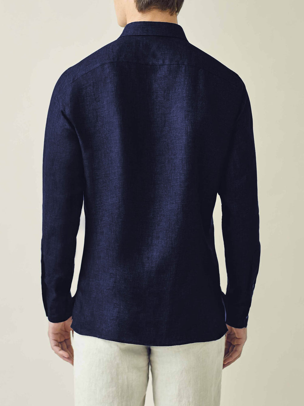 Back view of a model wearing the Ravello Linen Shirt in Midnight Blue.