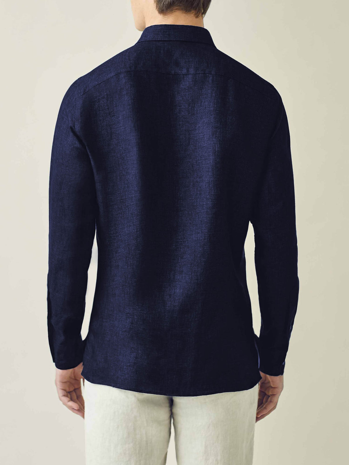 Back view of a model wearing the Ravello Linen Shirt in Midnight Blue.