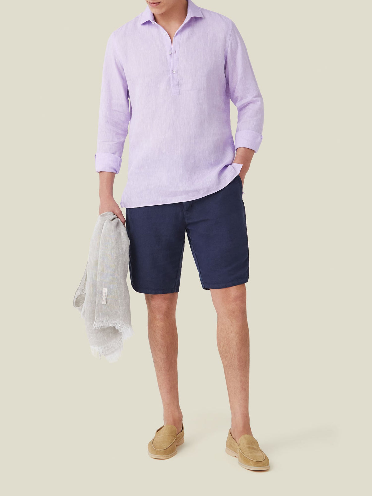 Full outfit view of a model wearing the lilac Ravello Linen Shirt with navy shorts and tan loafers.