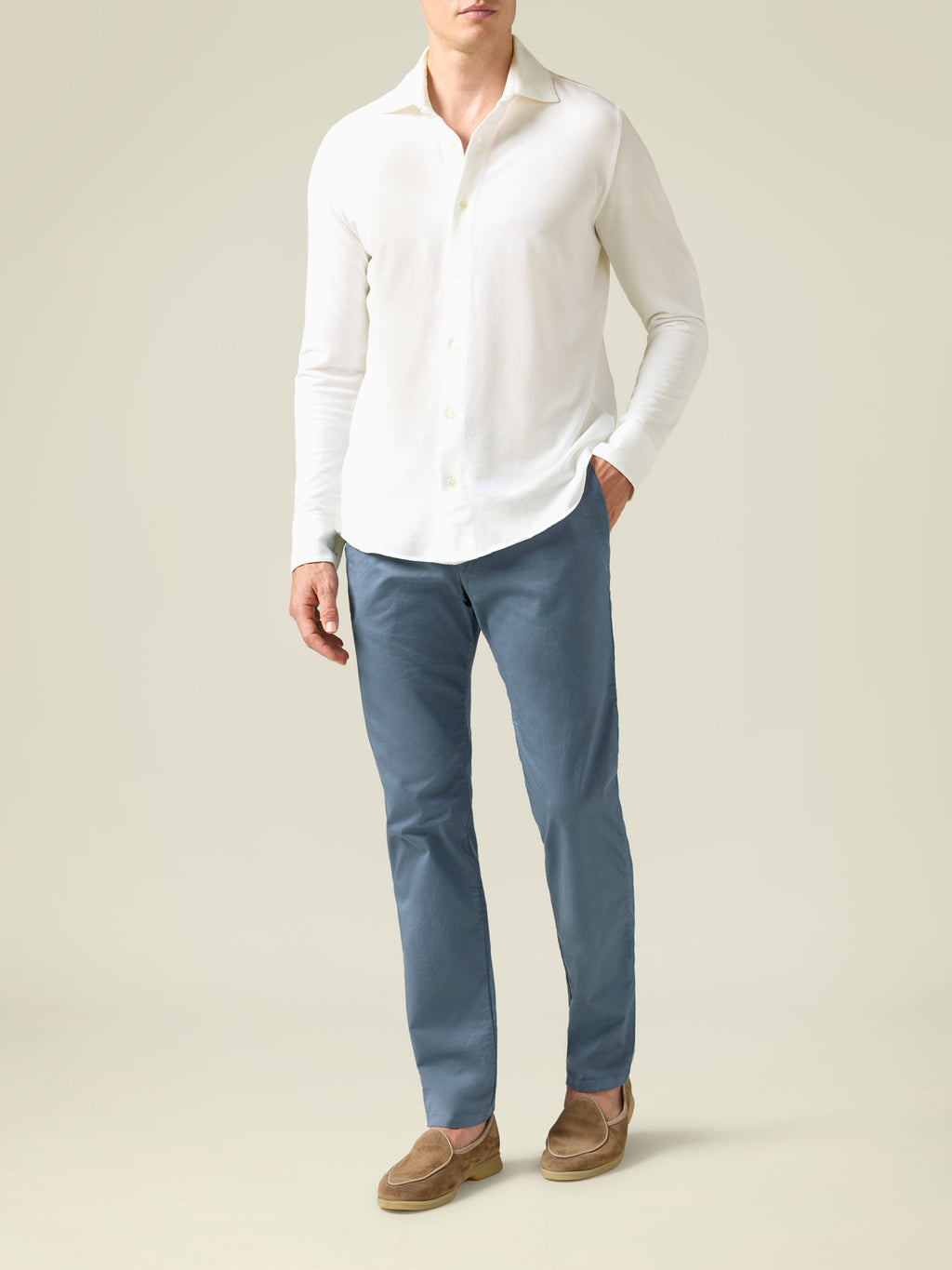 Front view of a model wearing the steel blue Lightweight Cotton Chinos, styled with a white long-sleeve shirt and loafers.