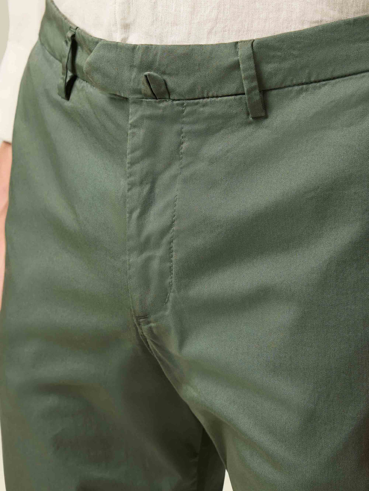 Close-up on the waist of the olive green Lightweight Cotton Chinos, showing the central belt fastener and whipcord fabric.