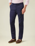 Man models navy blue Lightweight Cotton Chinos, styled with a pink shirt and brown suede loafers.