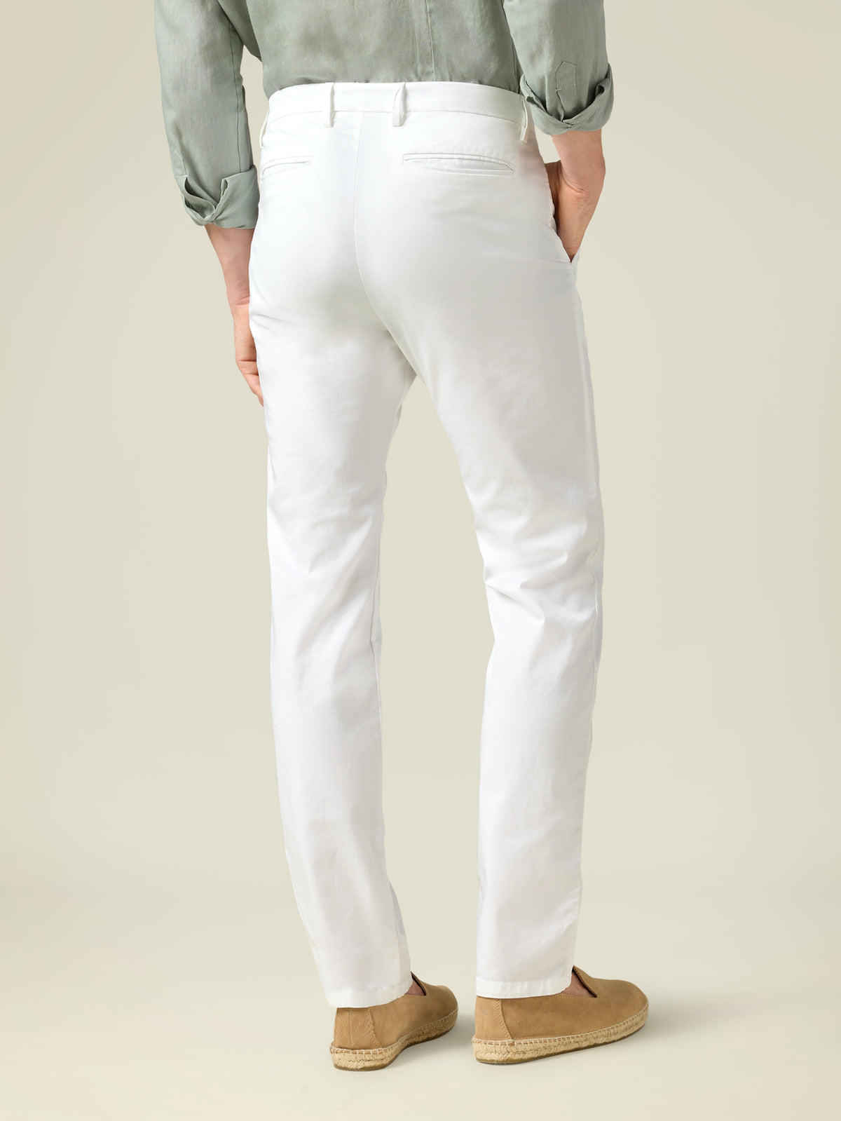 Back view of a model showing the tapered fit of the white Lightweight Cotton Chinos by Luca Faloni.