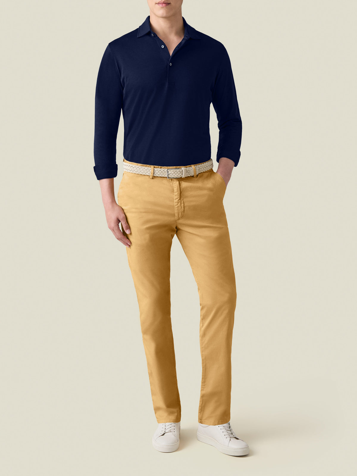 Front view of a model wearing the Mustard Lightweight Cotton Chinos, styled with a navy long-sleeve polo and white sneakers.
