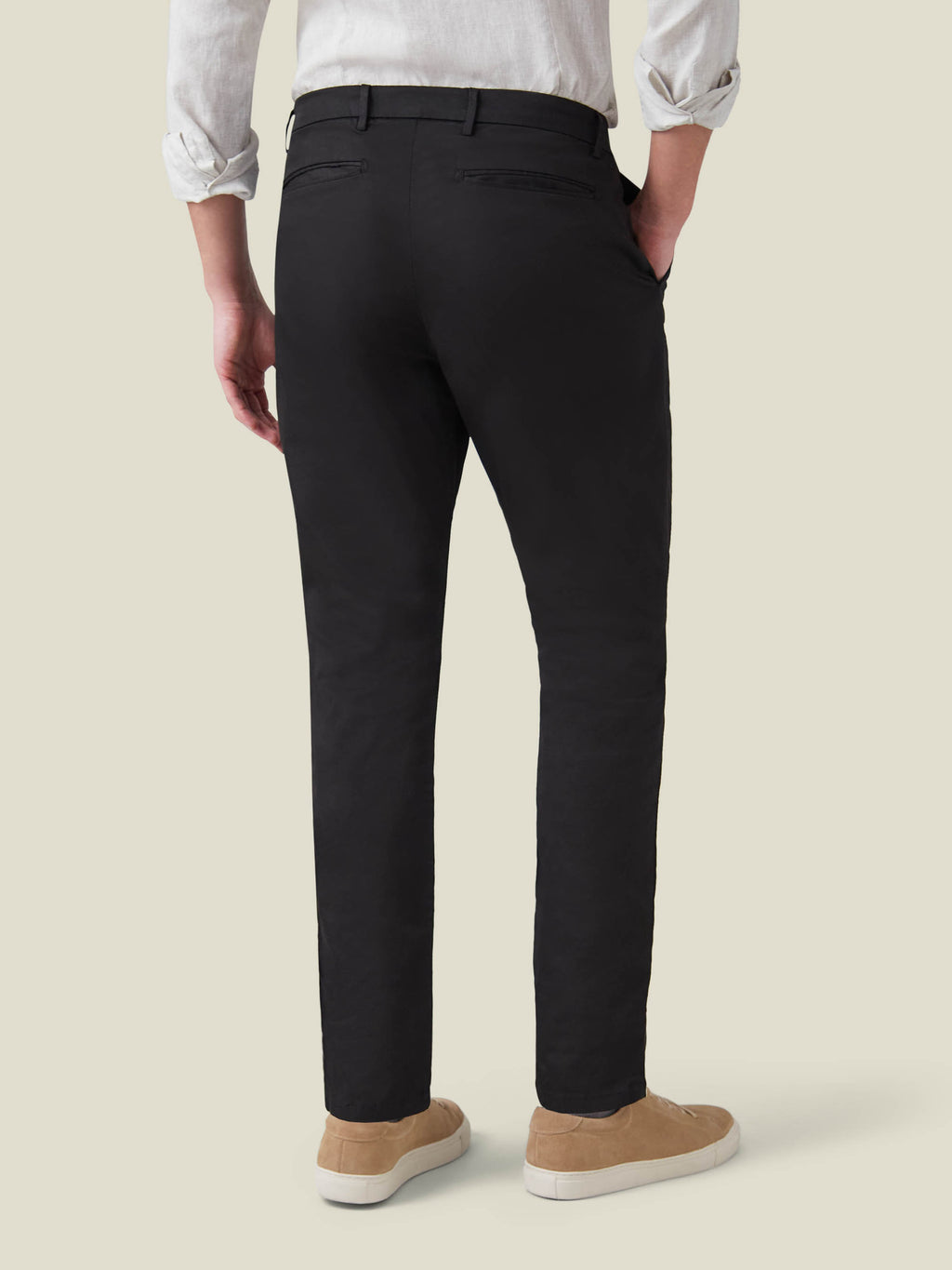 Back view of a model wearing Luca Faloni's Black Lightweight Cotton Chinos, highlighting the tapered fit.