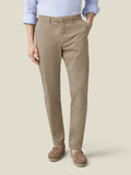 A man models the Hazelnut Brown Lightweight Cotton Chinos by Luca Faloni, paired with a light blue shirt and brown loafers.