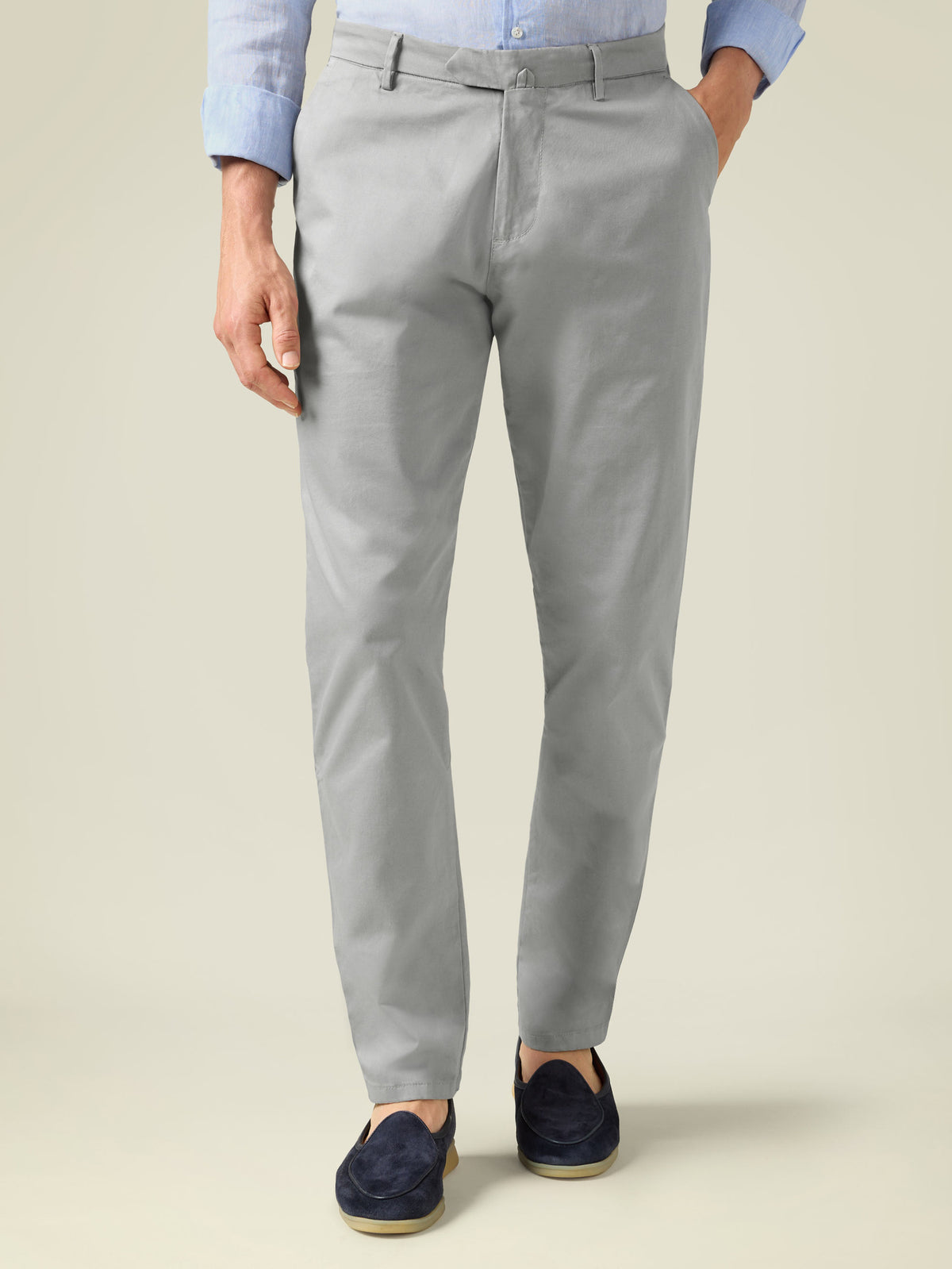 Front view of a model wearing Luca Faloni's Light Grey Lightweight Cotton Chinos paired with a blue shirt and navy loafers.