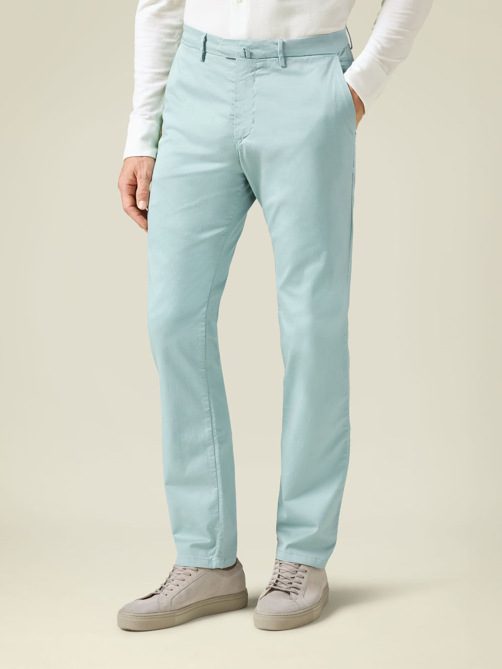 Side view of a man wearing Luca Faloni's Turquoise Lightweight Cotton Chinos with a white shirt and grey sneakers.