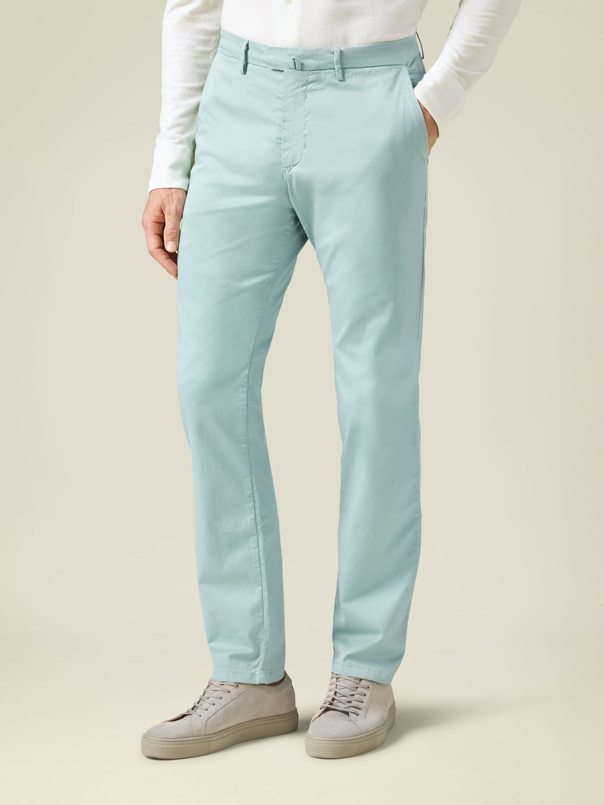 Side view of a man wearing Luca Faloni's Turquoise Lightweight Cotton Chinos with a white shirt and grey sneakers.