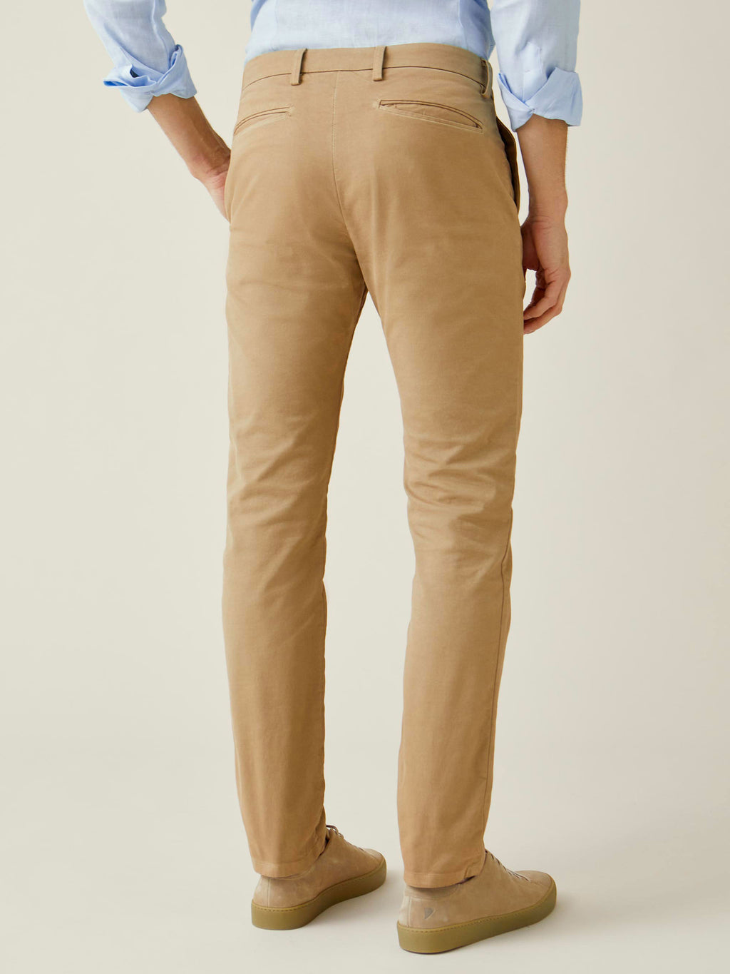 Back view of a model wearing the Cortina Cotton Chinos in Camel Beige, highlighting the tapered fit and back pocket details.