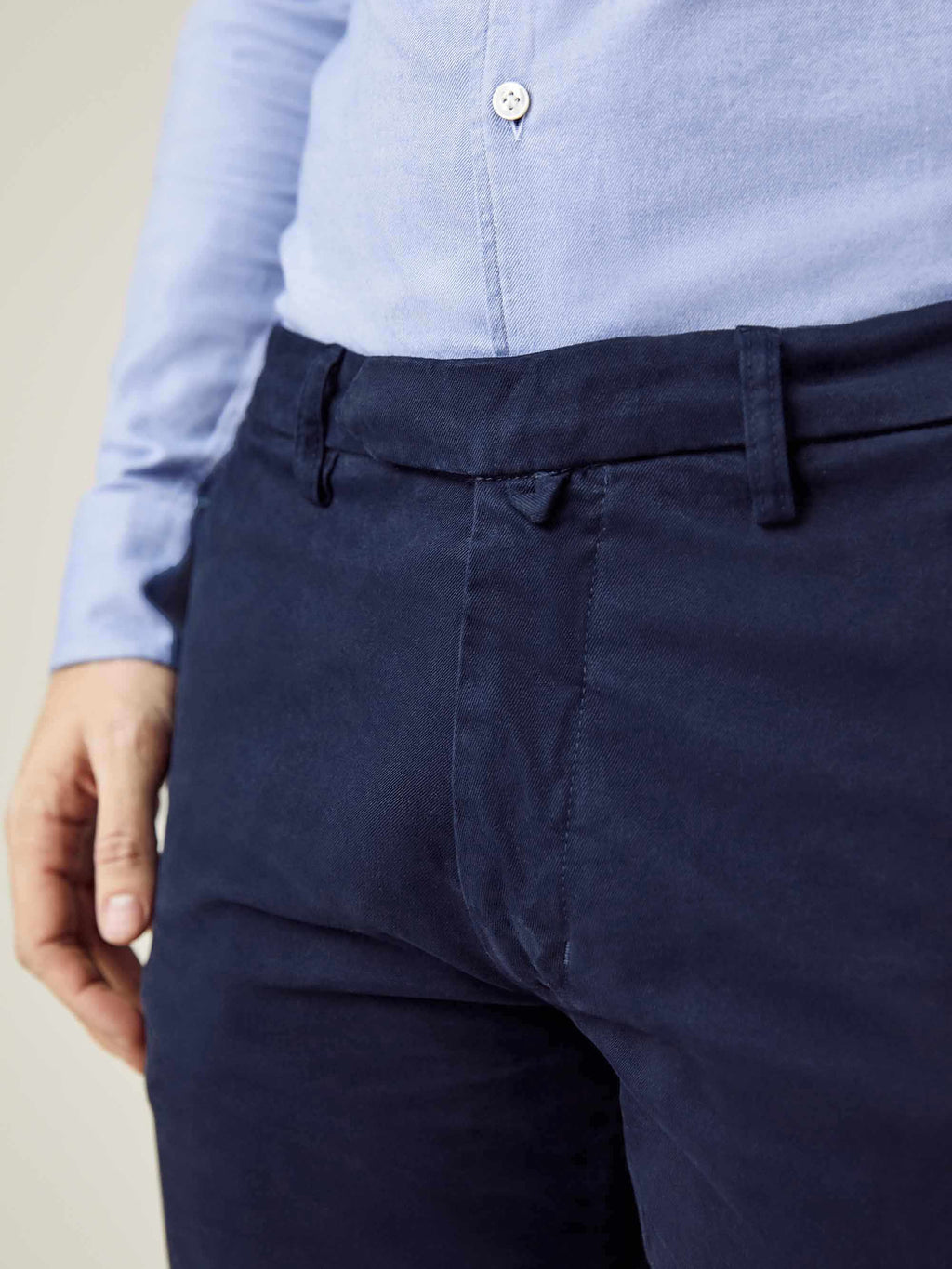 Close-up of the waistband and central fastener on the Navy Blue Cortina Cotton Chinos, paired with a light blue shirt.