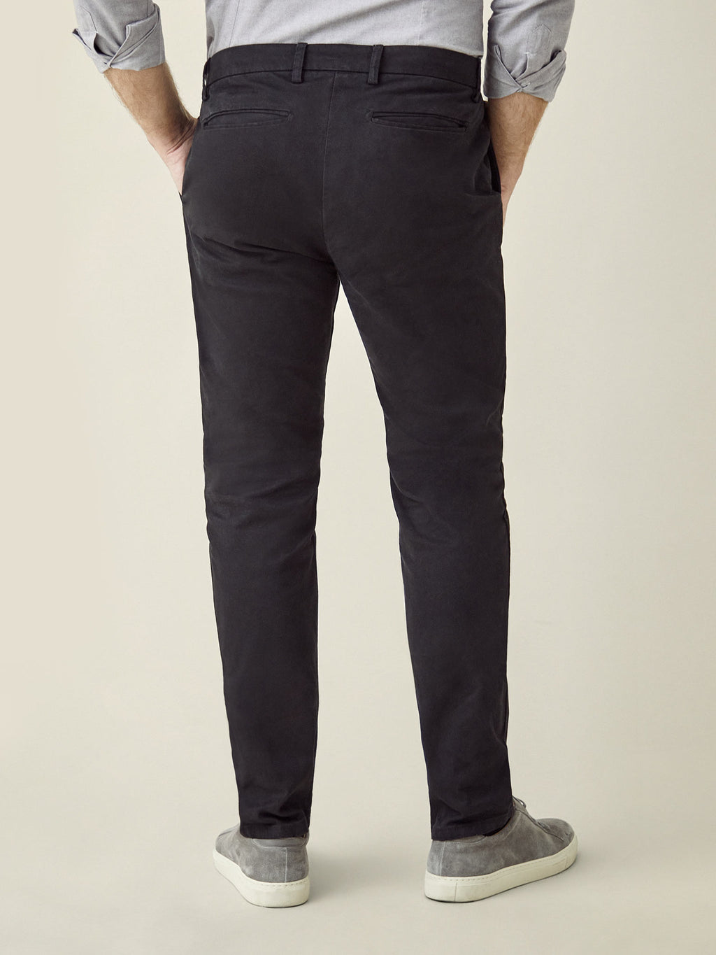 Back view of a man wearing Luca Faloni's Cortina Cotton Chinos in black, showcasing the tapered fit and back pockets.