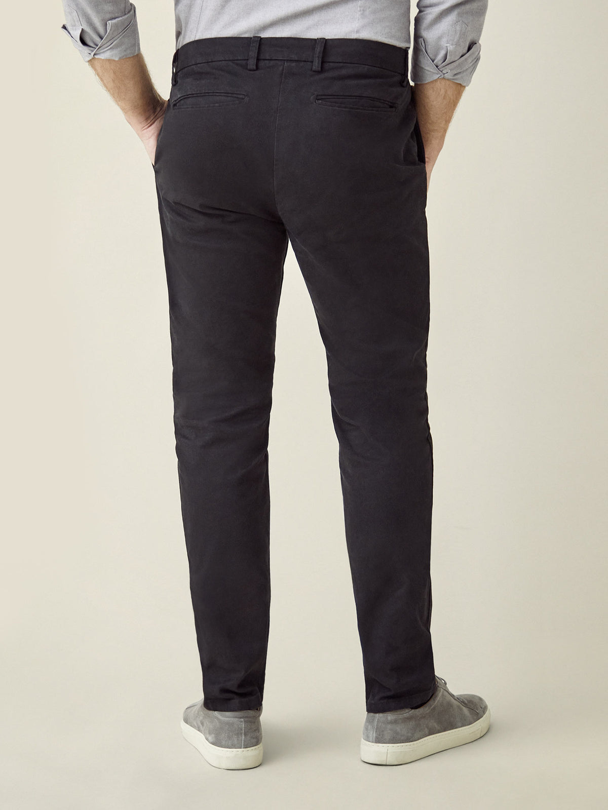 Back view of a man wearing Luca Faloni's Cortina Cotton Chinos in black, showcasing the tapered fit and back pockets.