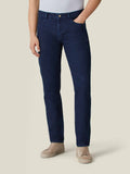 Front view of a model wearing Luca Faloni's dark blue tapered jeans with a white t-shirt and beige sneakers.