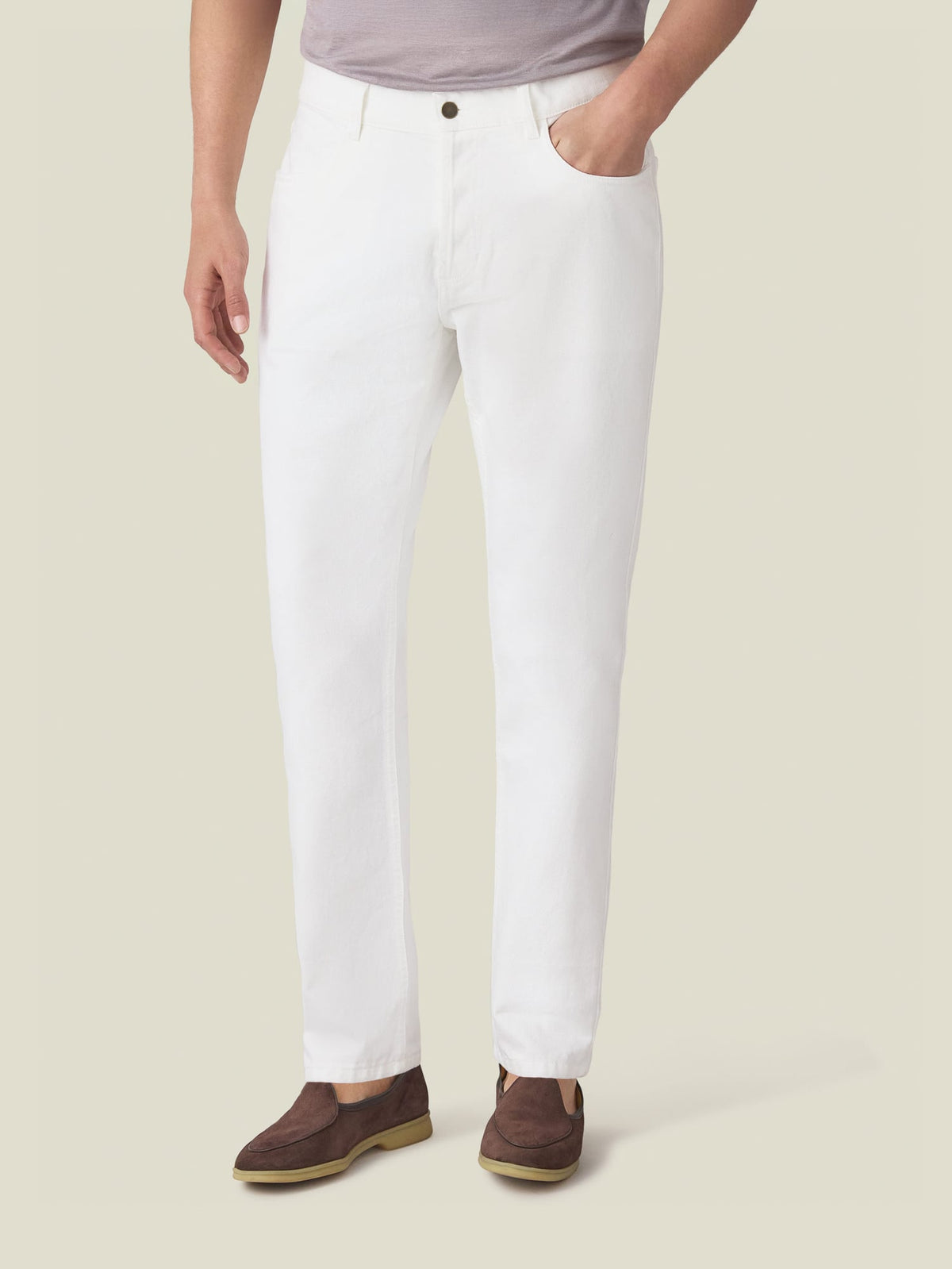 Front view of a model wearing Luca Faloni's white denim jeans, styled with brown loafers and a grey t-shirt.