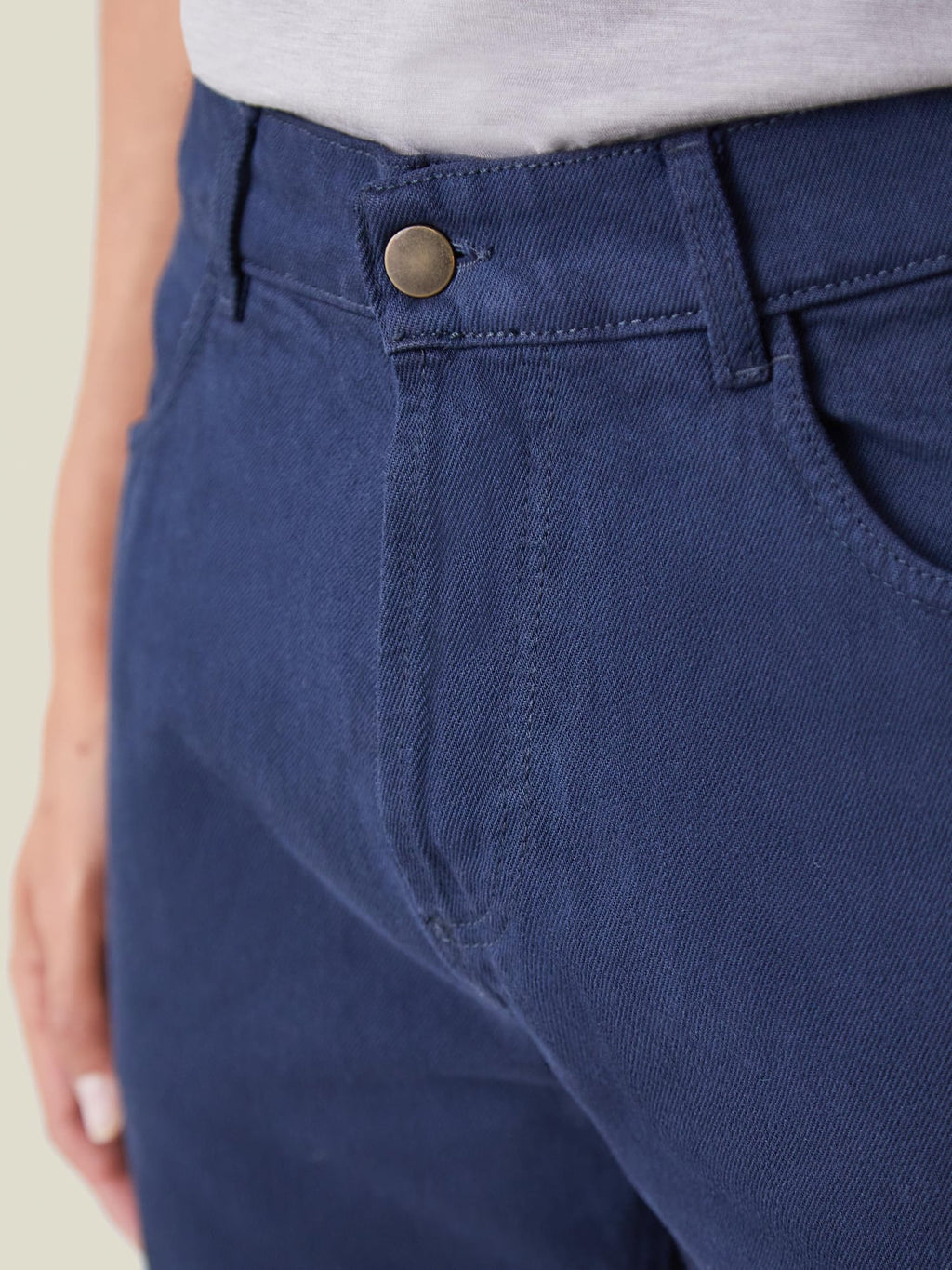 A close-up of Luca Faloni's Classic Blue Jeans, showcasing the button closure and its clean, rivetless design.