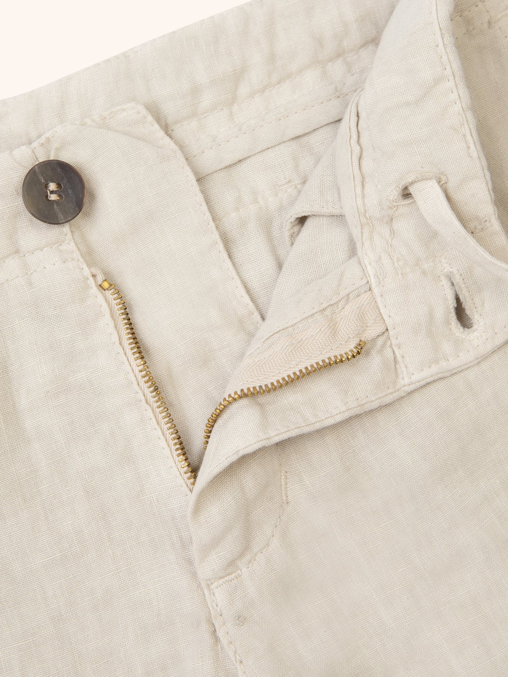 Close-up of the Sand Lipari Junior Linen Trousers, detailing the linen fabric, horn button, zip, and drawstring.