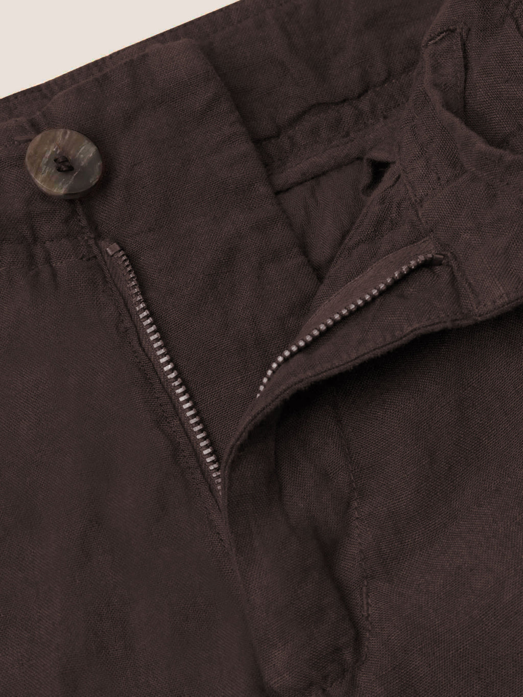 A close-up of the horn button and zip fly detail on the Chocolate Brown Lipari Linen Trousers.