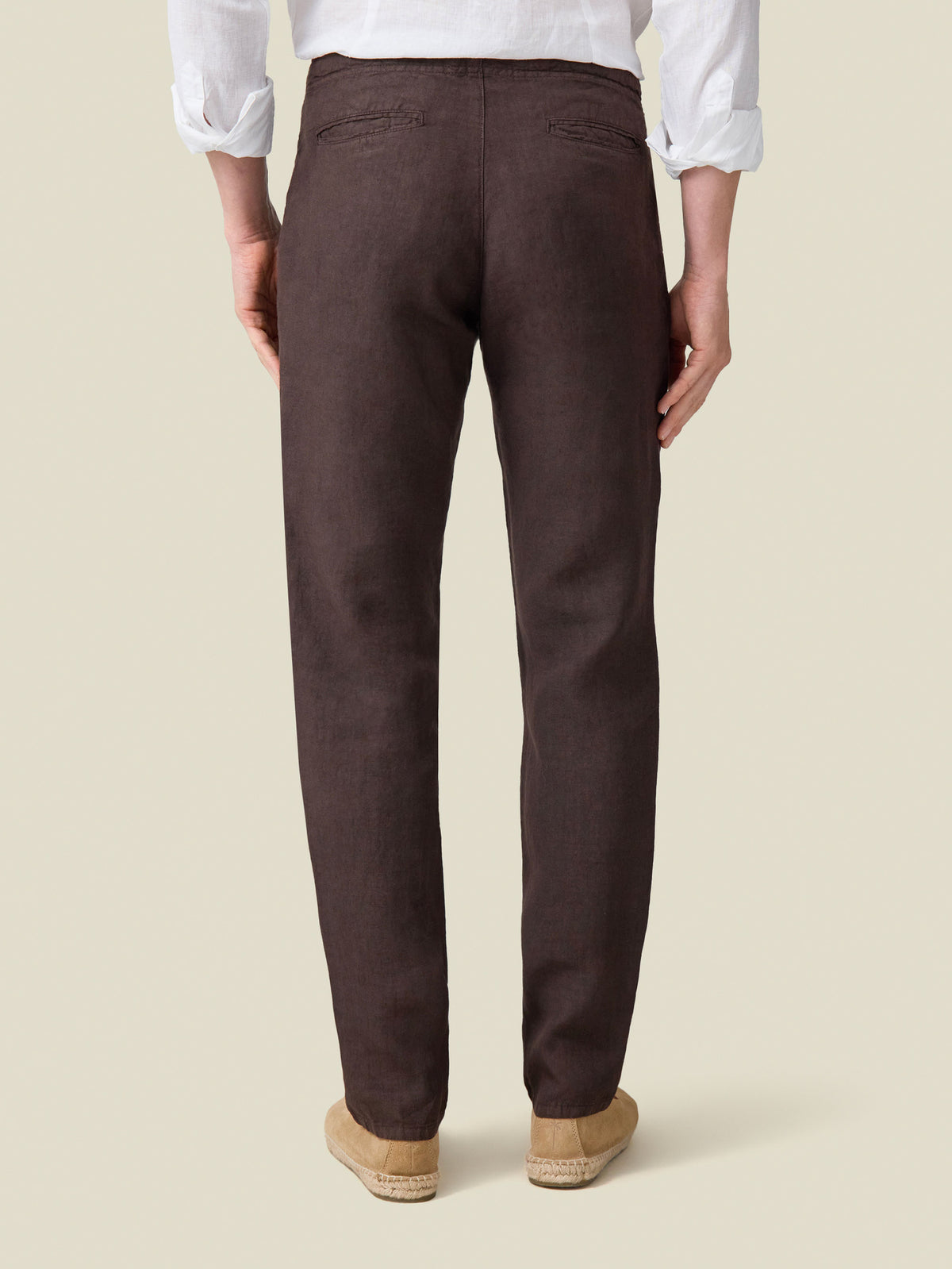 Back view of a model wearing the Chocolate Brown Lipari Linen Trousers.