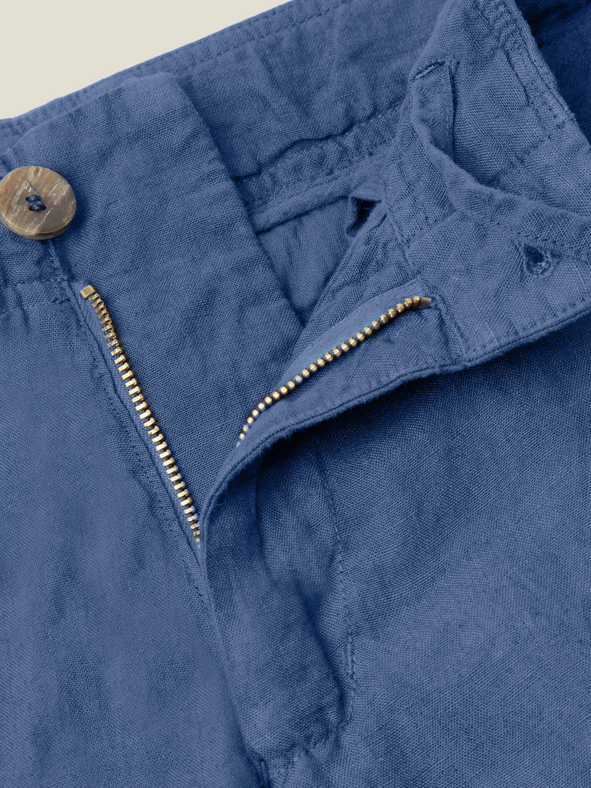 Close-up of the horn button and zip fly on the Lipari Linen Trousers in Capri Blue.