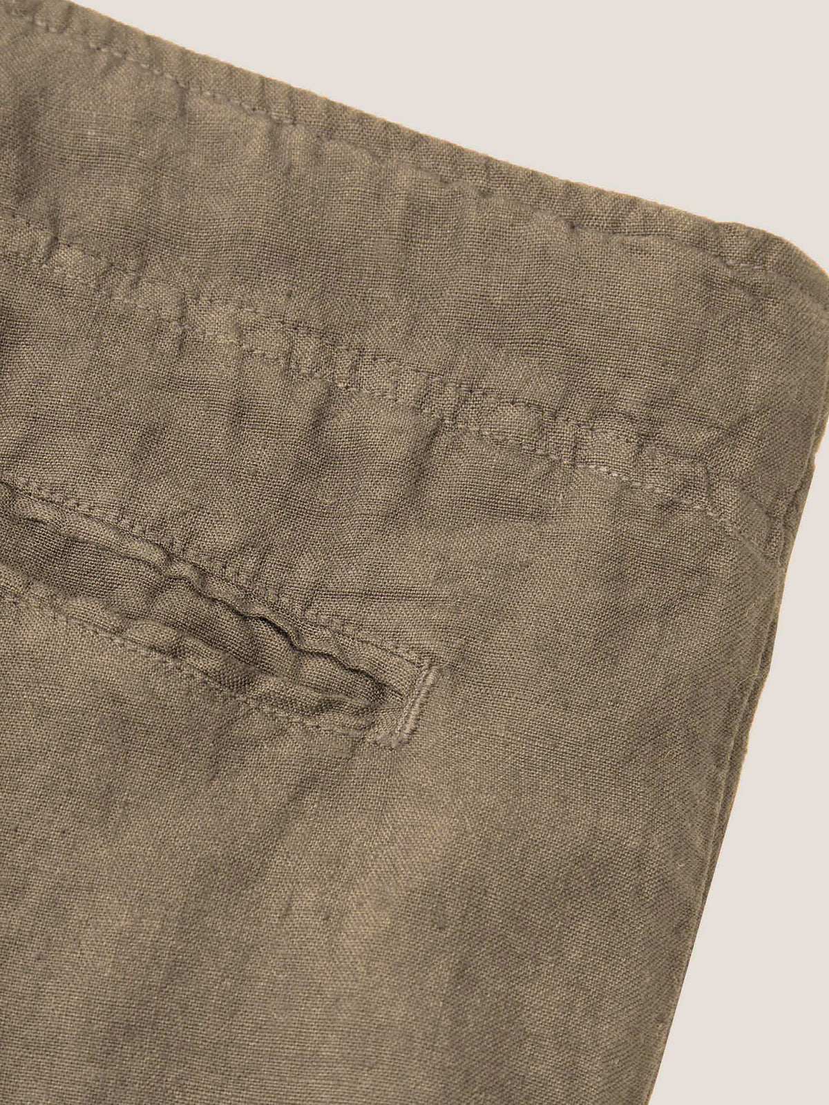 Close-up detail of the Lipari Linen Trousers in Hazelnut Brown, highlighting the back pocket and waistband stitching.