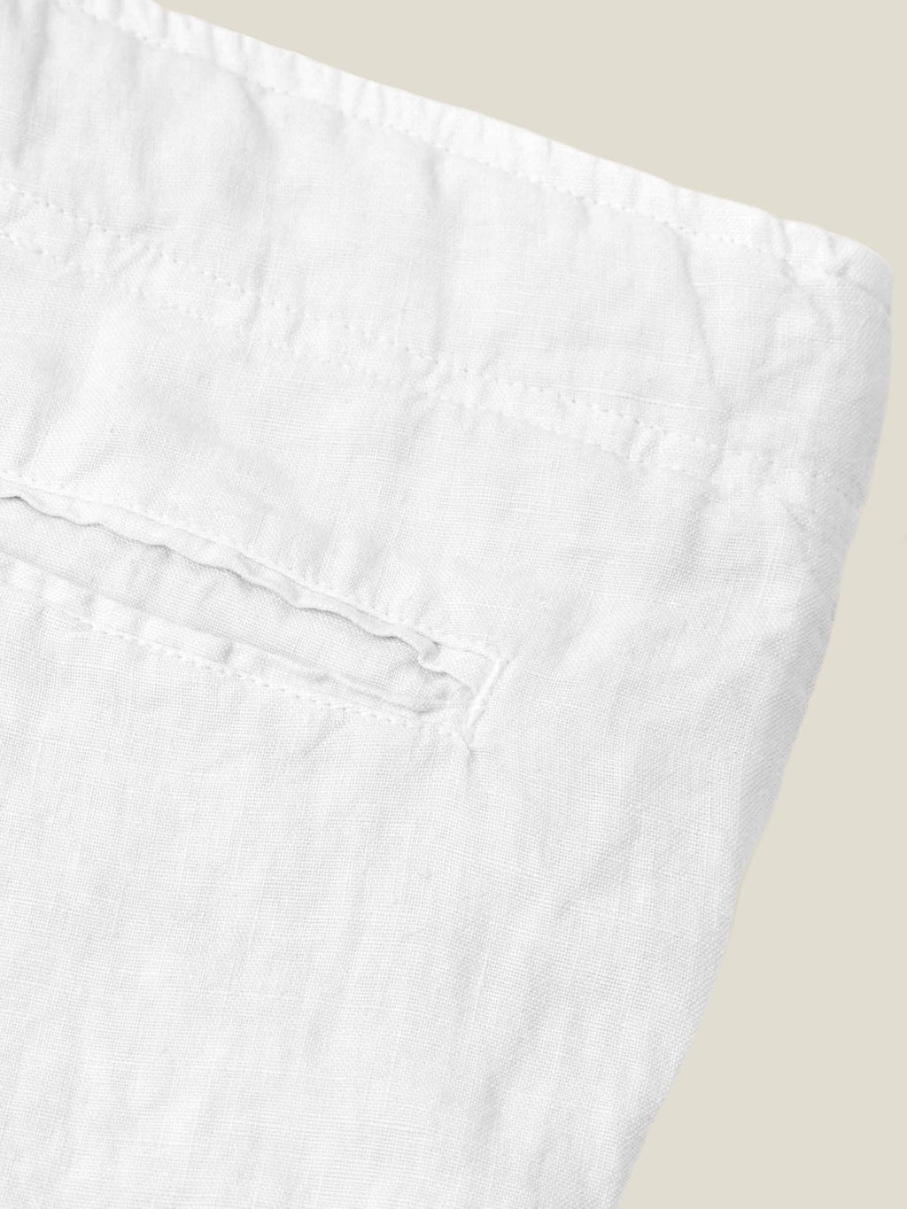 Close-up detail of the back pocket and pure Italian linen fabric on the white Lipari Linen Trousers.