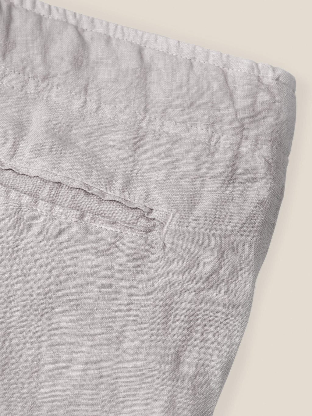 Close-up of the back pocket and waistband detail on the light grey Lipari Linen Trousers, made from Italian linen.